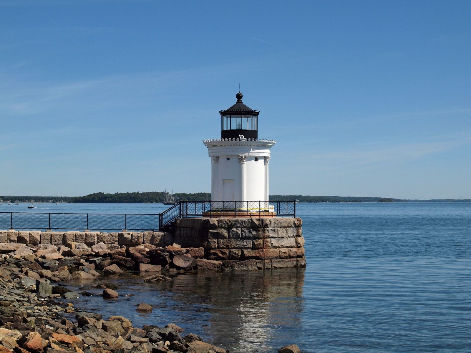 Scenic view of Bug Light Lighthouse by the rocky sea coast under a clear blue sky